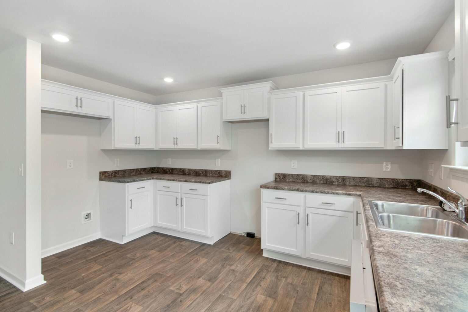 Newly renovated kitchen. brown granite countertops and white cabinets professionally cleaned by Cavanis Cleaning