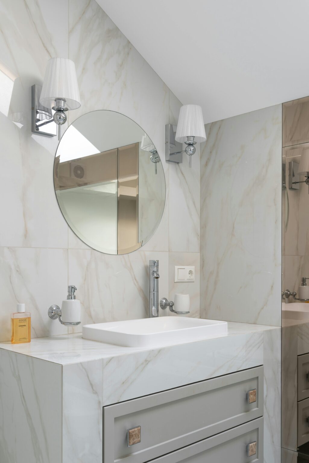 Spotless bathroom with a round mirror over the vanity