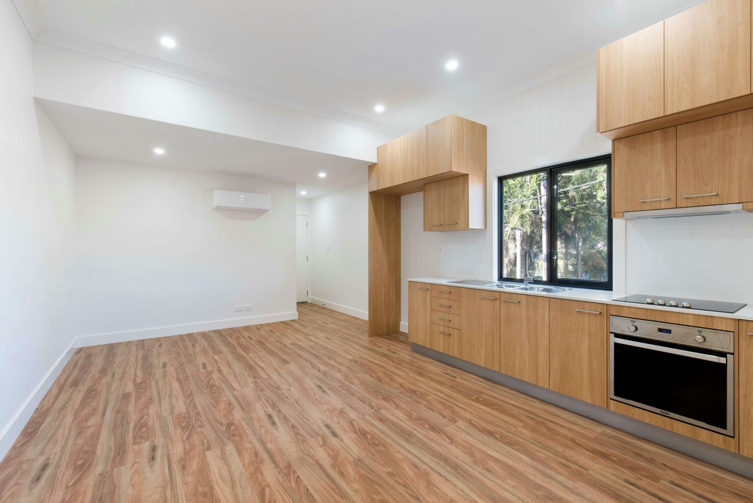 empty kitchen with wooden floor and cabinets