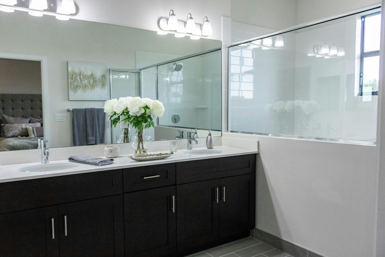 Bathroom with black cabinets and a large mirror