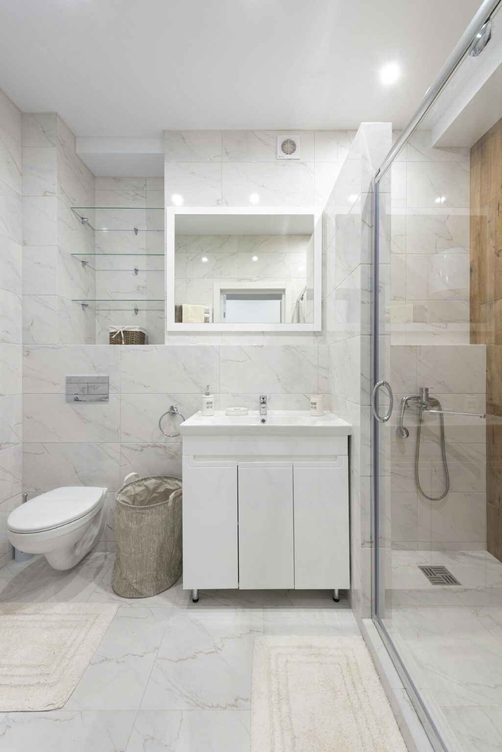 White-toned bathroom with a stand alone sink, walk-in shower, and a toilet